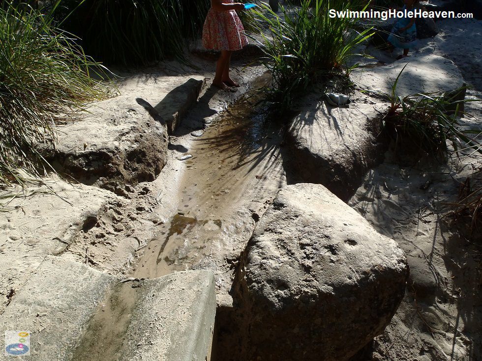 Playing in the sandy stream at the end of the mini-aqueduct at Wombat Bend playground in Lower Templestowe